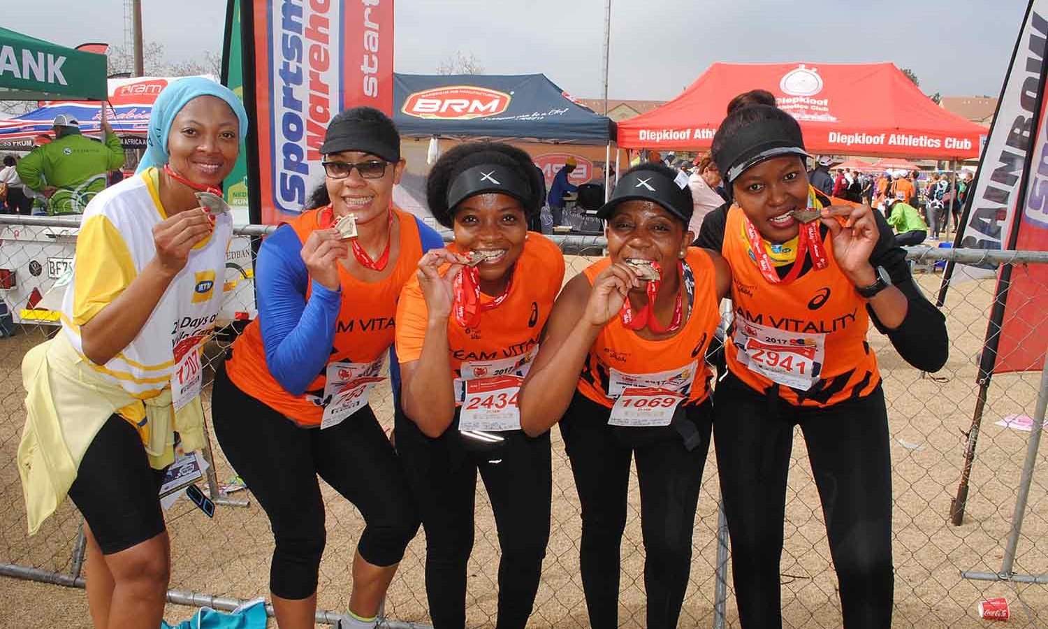 Group of runners in orange at the Wanderers Road Race